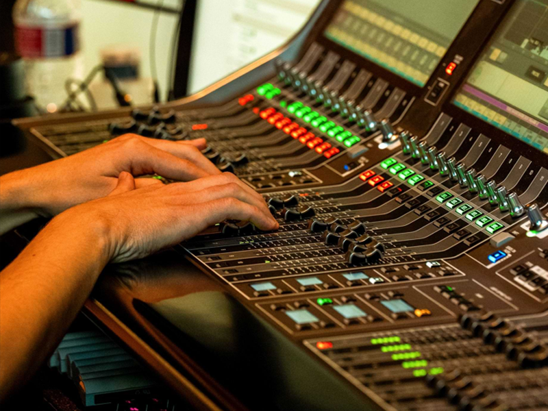 Person's hand on a swtich board with a microphone